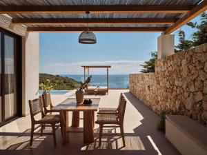 a table and chairs on a patio with a view of the ocean at Theros Luxury Suites in Agios Nikolaos