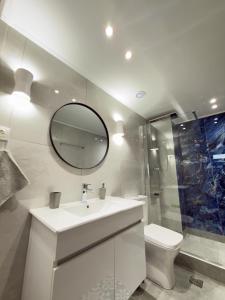 a bathroom with a sink and a toilet and a mirror at DNS Elements Apartments 2 in Nea Karvali +23 photos