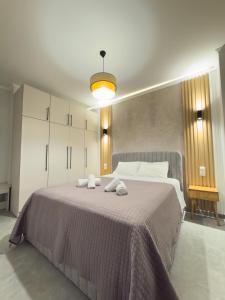 a bedroom with a large bed with towels on it at DNS Elements Apartments 2 in Nea Karvali