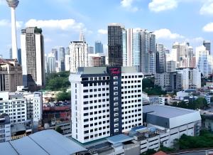 a tall white building with a kia sign on it in a city at Apex by Bukit Bintang Hotel in Kuala Lumpur