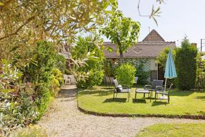 a garden with chairs and a table and an umbrella at Chambres D'hôtes 4 Saisons in Villefranche-Sur-Cher