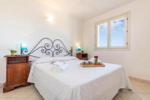 a bedroom with a white bed and a window at Elicriso - Happy Rentals in San Pasquale