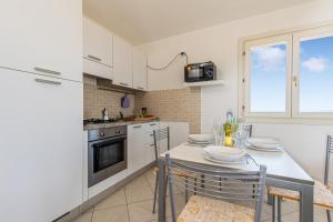 a kitchen with white cabinets and a table with chairs at Elicriso - Happy Rentals in San Pasquale