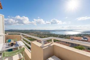 a balcony with a table and chairs and a view of the water at Elicriso - Happy Rentals in San Pasquale