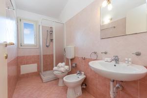 a bathroom with a sink and a toilet and a shower at Elicriso - Happy Rentals in San Pasquale
