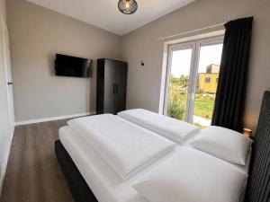 a bedroom with two white beds and a window at Beach House 314 in Hindeloopen