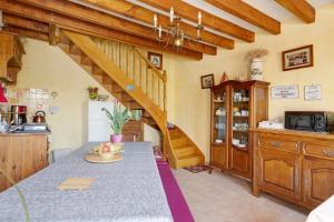 a kitchen with a table with a bowl of fruit at Chambres D'hôtes 4 Saisons in Villefranche-Sur-Cher