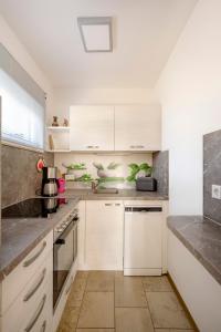 a kitchen with white cabinets and marble counter tops at Ferienhaus Krawulski in Hohnstein +9 photos