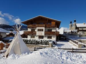 ein Haus im Schnee mit einer Schneepyramide in der Unterkunft Landhaus Tirol in Hopfgarten im Brixental