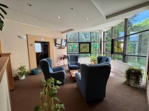 a living room with chairs and a room with windows at Apartmany Belianky in Tatranská Lomnica