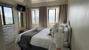 a bedroom with a bed with a view of the ocean at Beacon Wharf , George Hay 5 Seafront Accommodation in Mossel Bay