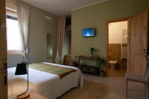 a bedroom with a bed and a tv on the wall at Vigne Del Garda in Villafranca di Verona