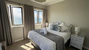 a bedroom with a large bed with a window at Beacon Wharf , George Hay 5 Seafront Accommodation in Mossel Bay