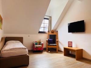 a bedroom with a bed and a tv on the wall at Family Hotel Schloss Rosenegg in Fieberbrunn