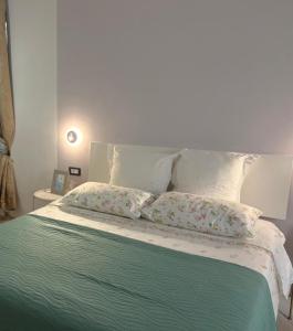 a bed with two pillows on top of it at Casa Acquarello in Savona