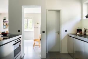 a kitchen with a white refrigerator and a chair at Luxury Nature Retreat Villa Planchette in Lugano