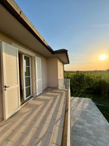 a house with a deck with the sunset in the background at Luxury Villa Cenaia in Cenaia Vecchia