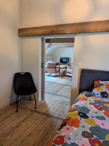 a bedroom with a bed and a chair in a room at BoerLangendijk in Rucphen