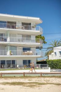 two people walking down a sidewalk in front of a building at Apartment with sea view Javea in Jávea