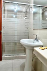 a bathroom with a sink and a glass shower at Hotel Esperanza in Lima