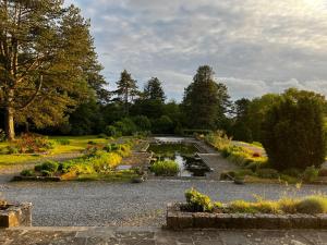 a garden with a pond and many flowers at Aux étangs fleuris in Rochefort