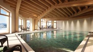 a large swimming pool with chairs in a building at Résidence Pierre & Vacances Capella in Avoriaz +26 photos