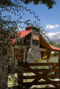 ein Haus mit einem Zaun davor in der Unterkunft Las Espuelas Casas de Montaña in Potrerillos