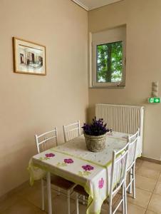 a dining room with a table with flowers on it at Villa Zose' luz in Káto Ássos +19 photos