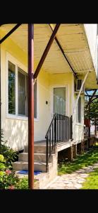 a house with stairs and a porch with a pole at Kitesa's apartment with two bedrooms in Mtskheta