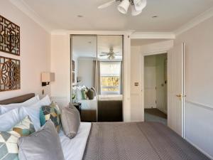 a bedroom with a bed with a ceiling fan at Collingham Serviced Apartments in London