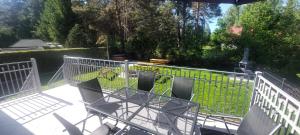 a table and chairs on a patio with a fence at Apartament AURA - Cichy Zakątek - Kujanki in Kujanki +42 photos