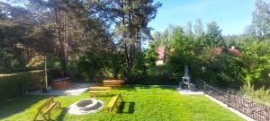 a backyard with a picnic table and benches at Apartament AURA - Cichy Zakątek - Kujanki in Kujanki