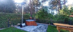 a backyard with a grill and a wooden bench at Apartament AURA - Cichy Zakątek - Kujanki in Kujanki