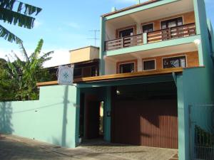 an apartment building with a garage in front of it at Canto Leste Pousada in Florianópolis