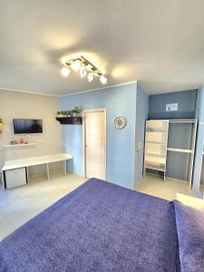 a bedroom with blue walls and a purple bed at Scilla Guest House in Scilla