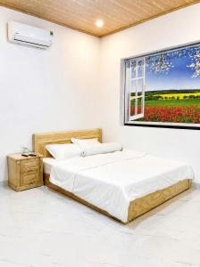 a bedroom with two beds and a window with flowers at Phước Hải Đẹp Homestay in Chợ Phước Hải