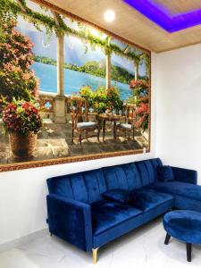 a blue couch in a room with a painting on the wall at Phước Hải Đẹp Homestay in Chợ Phước Hải
