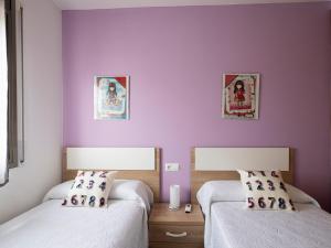 two beds in a room with purple walls at Villa Joan in Riumar +26 photos