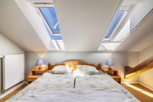 a bedroom with a bed with skylights at Hof am Ammersee in Pähl