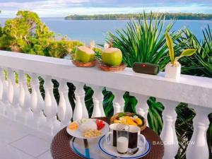 a breakfast on a balcony with a view of the ocean at The Clifftop Home in Esperanza