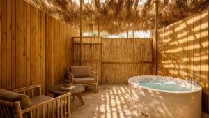 a bath tub in a room with a chair at Jacob Mitzpe Ramon in Mitzpe Ramon