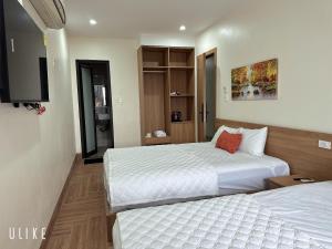 a hotel room with two beds and a television at Lala hotel in Phủ Từ Sơn