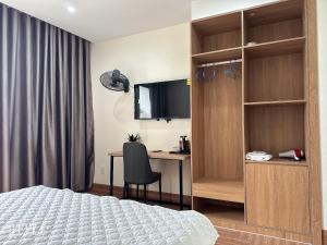a bedroom with a bed and a desk and a television at Lala hotel in Phủ Từ Sơn