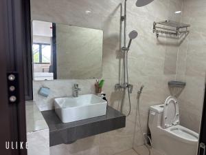 a bathroom with a sink and a toilet and a mirror at Lala hotel in Phủ Từ Sơn +16 photos