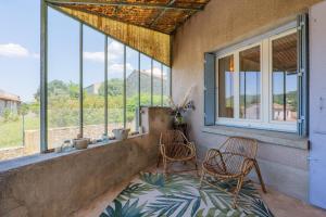 two chairs sitting on a porch with windows at Charmante Maison Vallon pont d'Arc in Vallon-Pont-dʼArc