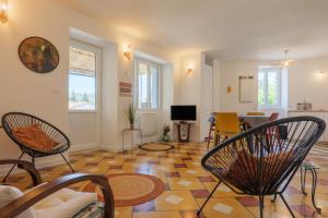 a living room with chairs and a dining room at Charmante Maison Vallon pont d'Arc in Vallon-Pont-dʼArc