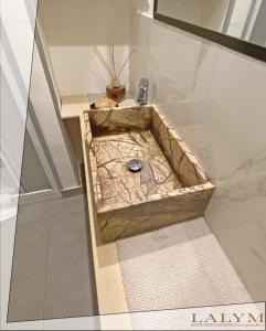 a bathroom with a stone sink in a room at Lalym Donnanna Apartment in Rossano Stazione +23 photos