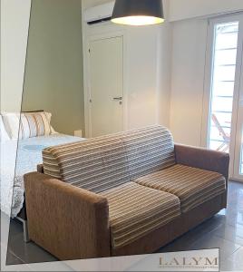 a living room with a couch and a bed at Lalym Donnanna Apartment in Rossano Stazione