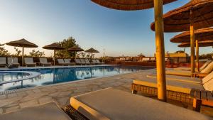 a swimming pool with lounge chairs and umbrellas at Jacob Mitzpe Ramon in Mitzpe Ramon