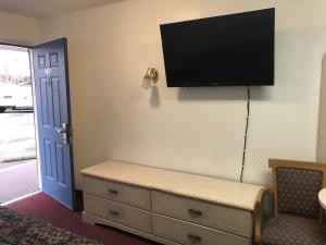 ein Wohnzimmer mit einem Flachbild-TV an der Wand in der Unterkunft Mayfair Motel in Cross Keys